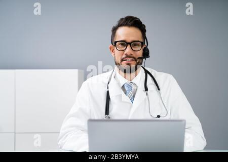 Close-up Portrait Of Confident Receptionist Using Headset In Hospital Stock Photo