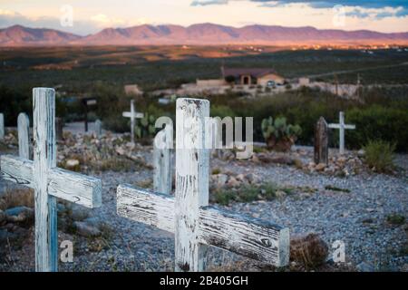 Two wooden cross grave markers overlooking hills in famous Boothill graveyard in Tombstone, Arizona. Sunset in distance, no people visible. Stock Photo