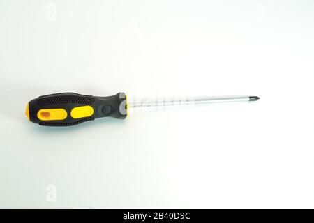 Close-up photo of black and yellow screwdriver on the white background. Stock Photo