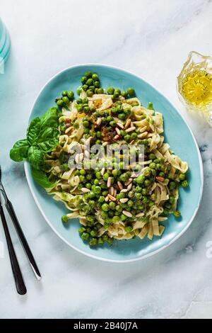 spring homemade Italian pasta with chickpea flour and pesto with fresh green peas and pine nuts. delicious mediterranean cuisine Stock Photo