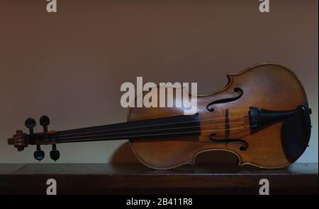 Violin sitting on its side and resting on a table. Stock Photo