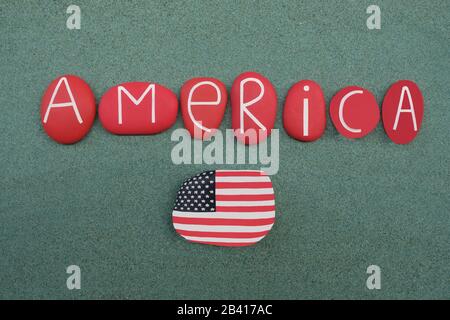 America, United States of America, souvenir with red colored stone letters and national flag design on a rock with green sand background Stock Photo