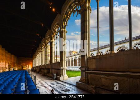 A large hall inside the Camposanto Monumentale, the gothic cemetery inside Cathedral Square in Pisa, Italy, with the duomo cathedral in view Stock Photo