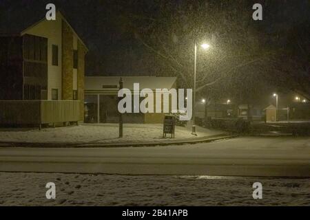 Newport News, VA/USA, February 20, 2020: A residential street within a brick apartment complex on a snowy night. Stock Photo