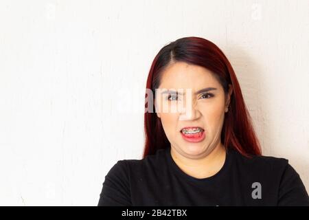 Hispanic white-skinned redhead woman showing anger, frustration, anger and other negative emotions on a white background Stock Photo