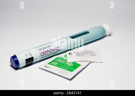 Aimovig (erenumab-aooe) 70 mg auto-injector device, prescription drug migraine prevention, alcohol wipe, spot bandage, studio, color, United States Stock Photo