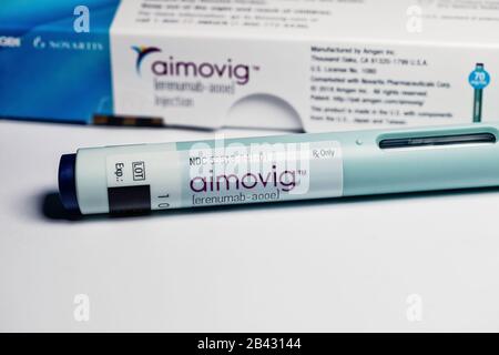 Closeup of Aimovig (erenumab-aooe) 70 mg auto-injector device, prescription drug for migraine prevention, and box, studio, color, United States Stock Photo