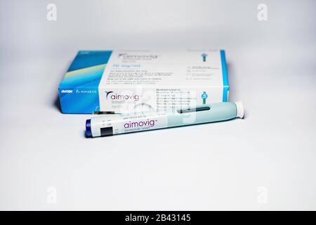 Aimovig (erenumab-aooe) 70 mg auto-injector device, prescription drug for migraine prevention, and box, studio, color, United States Stock Photo