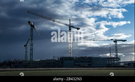 Construction cranes at a construction site in Augsburg on Bundesstrasse 17, Swabia, Bavaria, Germany, Europe Stock Photo