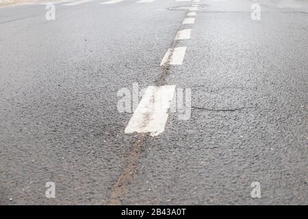 old asphalt texture with white dashed line.country road.black asphalt road background and white dividing lines. Color guidelines on Street. Stock Photo