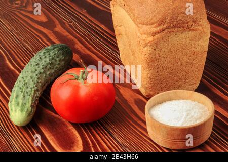 Bread with salt and vegetables on the table Stock Photo