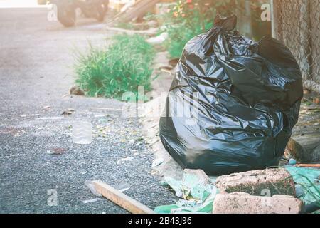 pile black garbage bag plastic and four dustbin dirty roadside in the city  with copy space add text Stock Photo - Alamy