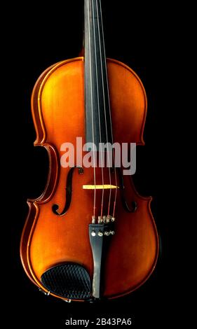 Studio photo of an aged violin shot against a black background.