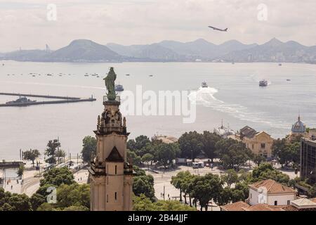 City centre port area with the Dom João VI statue monument and XV Square in the foreground and ferry boats to and from Niteroi in the background Stock Photo