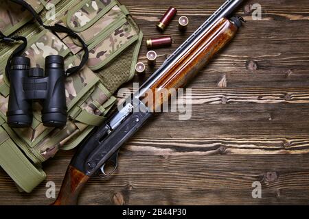 Hunting rifle and ammunition on a dark wooden background.Top view., Hunting rifle and ammunition on a dark wooden background.Top view. Stock Photo