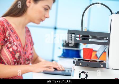 Young female designer works with a home 3D printer Stock Photo