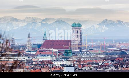 Frauenkirche with snow-capped alps (mountains) in the background. Symbol & landmark of the bavarian capital. Beautiful panorama captured during winter Stock Photo