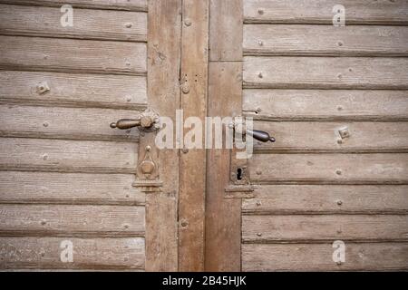 close up old vintage wooden decorated door with an iron door handle . Stock Photo