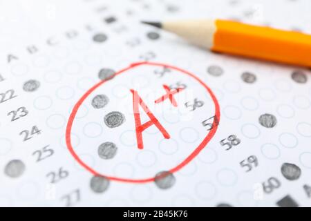 Test score sheet with answers, grade A+ and pencil, close up Stock Photo