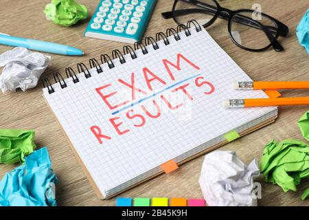 Inscription Exam, Results and stationary on wooden background, close up Stock Photo