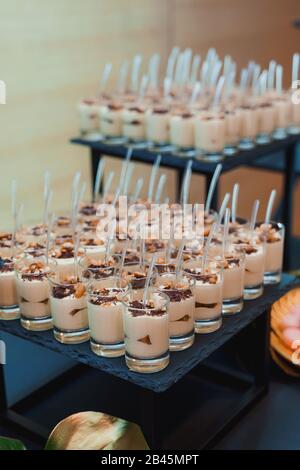 Glasses of panna cotta garnished with chocolate and caramelized pear Stock Photo
