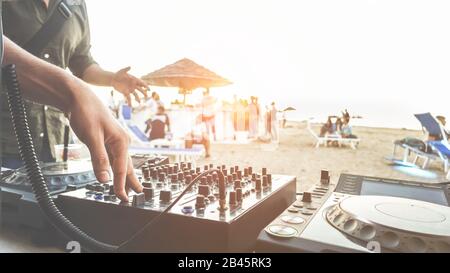Dj mixing at sunset beach party in summer vacation outdoor - Disc jockey hands playing music for tourist people in chiringuito kiosk bar - Event, musi Stock Photo