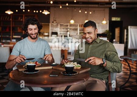Friends enjoying italian brischetta food in cafe with coffee while laughing during conversation Stock Photo