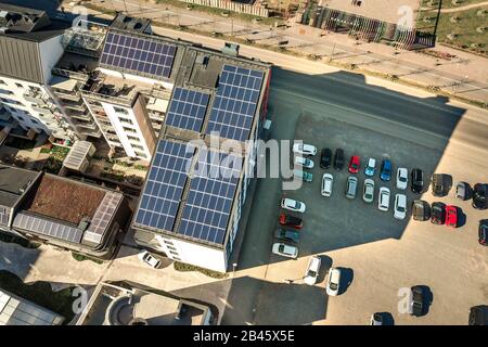 Aerial view of solar photovoltaic panels on a roof top of residential building block for producing clean electric energy. Autonomous housing concept. Stock Photo