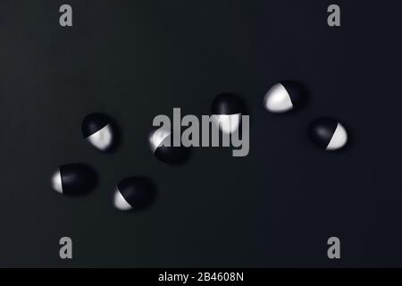 Seven black and silver Easter eggs on dark grey background. Flat lay, top view, copy space. Stock Photo