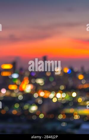 Vertical cover of blurred bokeh cityscape at twilight time, city background, aerial view angle from rooftop ob building, defocused city in downtown,gr Stock Photo