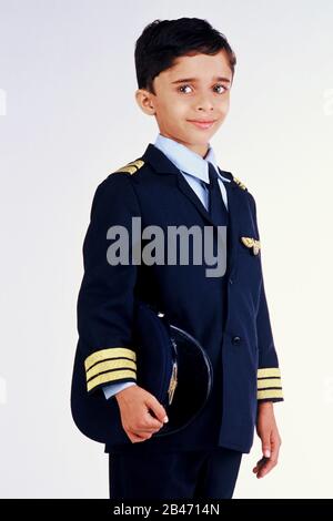Boy in fancy dress costume of airline pilot wearing blazer and holding hat, MR# Stock Photo