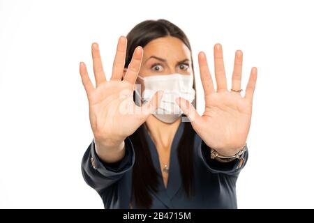 Angry woman with stop hands and protective mask on her face on white background Stock Photo