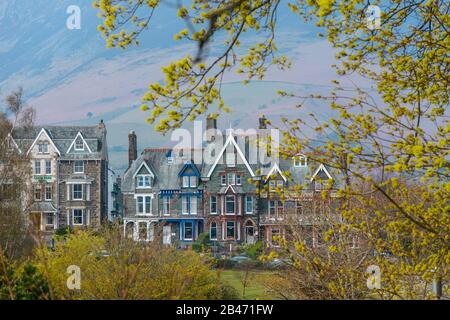 A row of Victorian houses (hotels) overlooking Crow Park on the northern shore of Derwentwater in Keswick, Lake District, UK, with the Skiddaw behind. Stock Photo