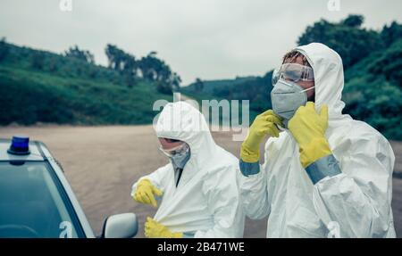 Two young people putting on bacteriological protection suits Stock Photo