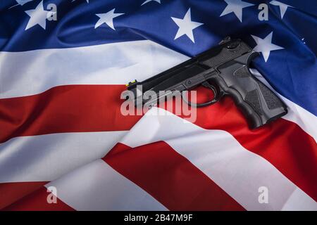 Handgun lying on American flag. Weapon problem concept Stock Photo