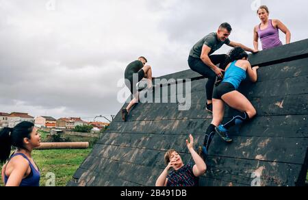 Participants in obstacle course climbing pyramid obstacle Stock Photo