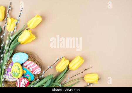 Yellow tulips and Easter cookies on a beige background Stock Photo