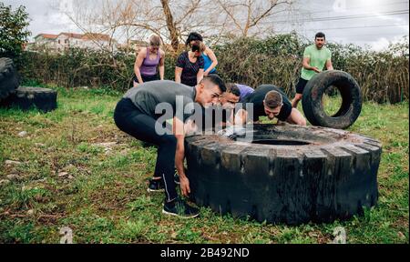 Participants in an obstacle course turning a wheel