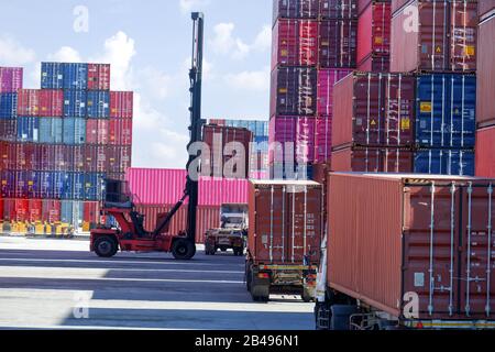 Container lifting equipment for working on boats and trucks waiting to receive goods Stock Photo