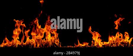 On fire flames at the black background, Burning red hot sparks rise, Fiery orange glowing flying particles Stock Photo