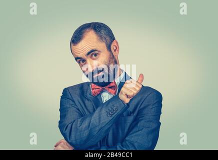 Look up here. Your text product here. Portrait of handsome mature man presenting blank copy space isolated on light green white office wall background Stock Photo