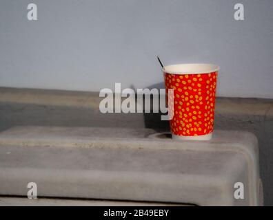 Cardboard - paper cup of coffee placed on the stones of a jetty in