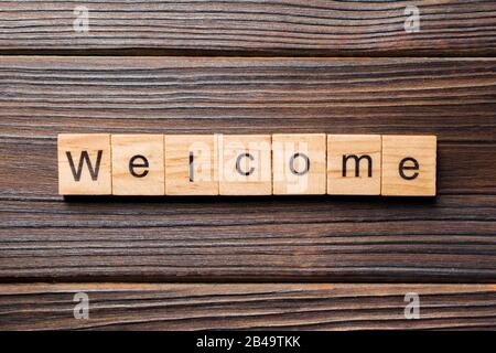 WELCOME word written on wood block. WELCOME text on table, concept. Stock Photo