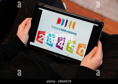 Bordeaux , Aquitaine / France - 11 30 2019 : France Television group on screen woman sitting couch using tablet touch pad watch french tv Stock Photo