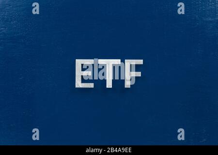 the abbreviation word etf - Exchange Traded Fund - laid with silver letters on blue color flat surface Stock Photo