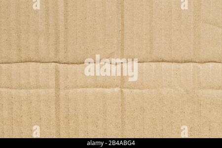 Folded corrugated cardboard surface texture background. Seamless crumpled brown paper textured backdrop. Stock Photo
