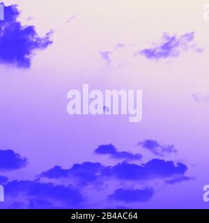 Moon behind the clouds, violet blue toned Stock Photo