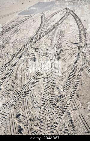 Tyre tracks and footprints in sand Stock Photo