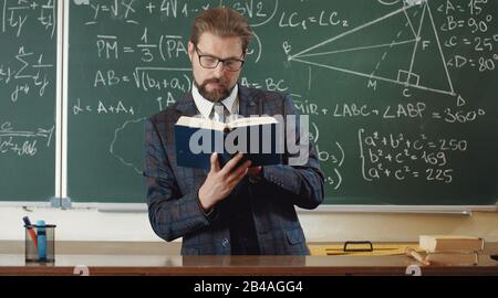 Teacher Read Math Math teacher reading book in classroom Stock Photo - Alamy
