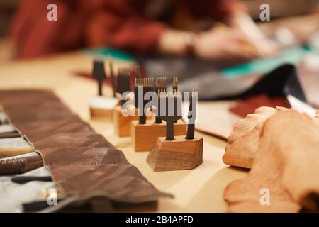 Horizontal close up shot of leather hole punch tools on table in modern craft workshop Stock Photo